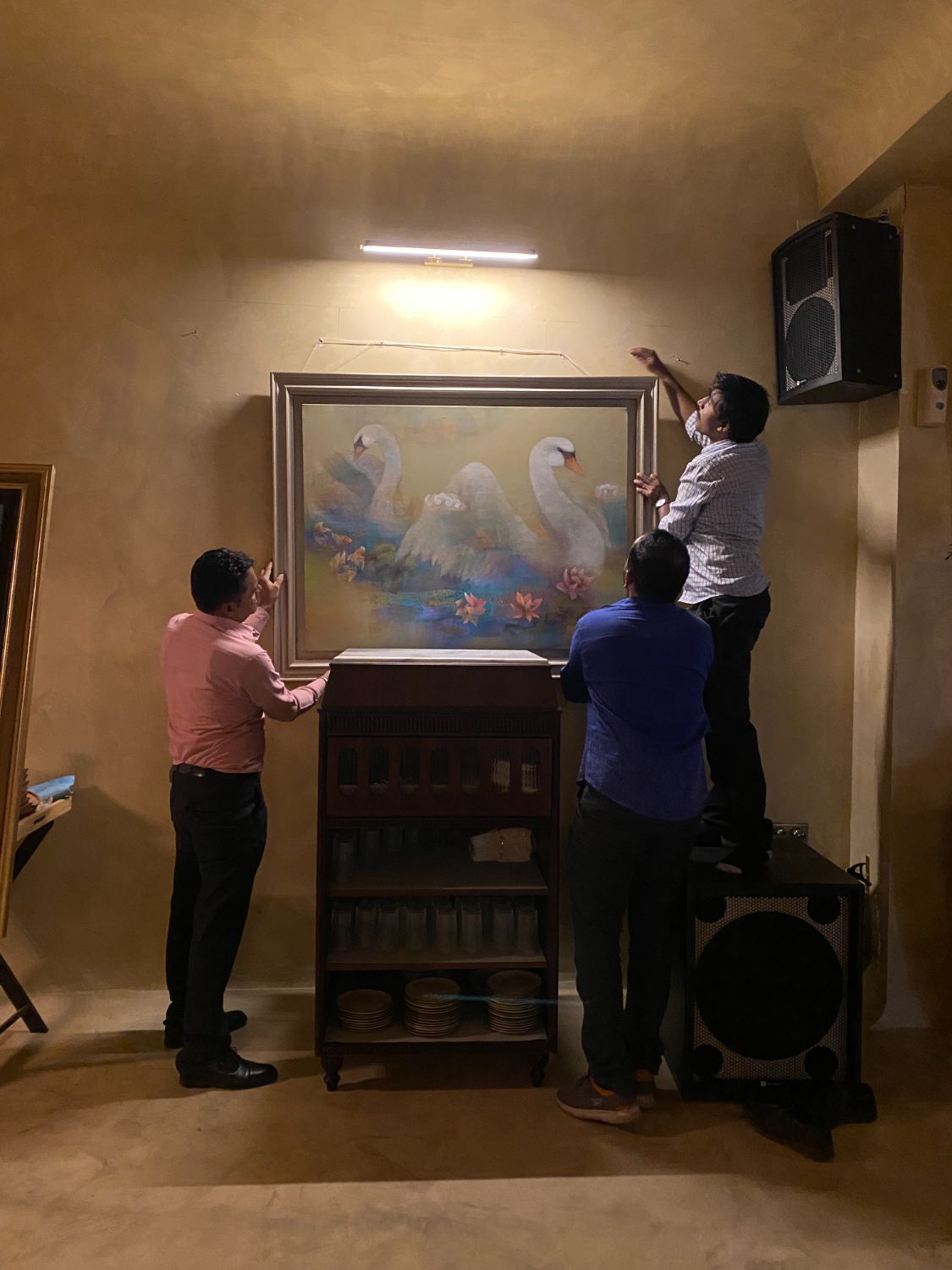 Installing the swan painting above a console