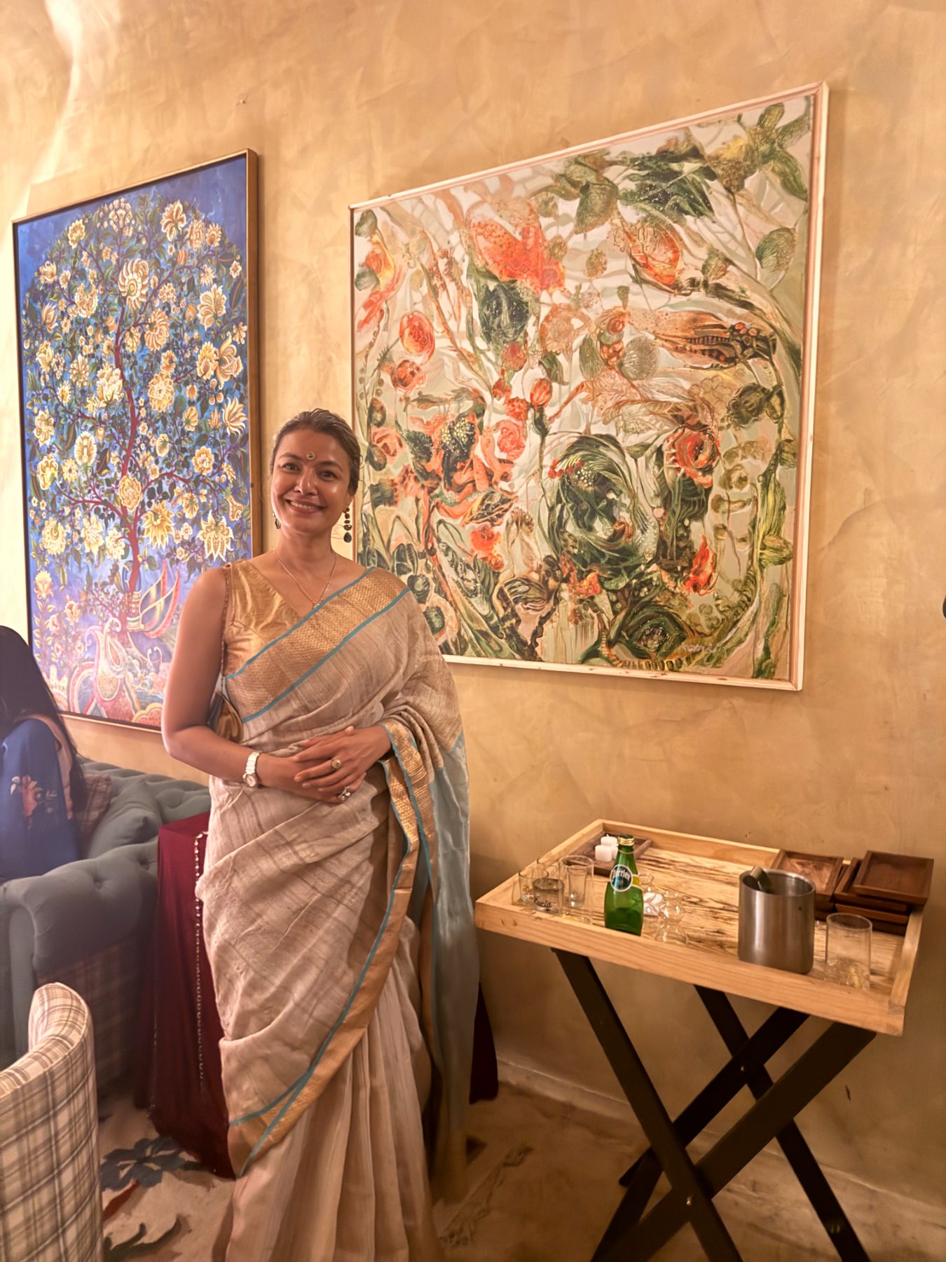 A guest before the floral and tree-of-life canvases