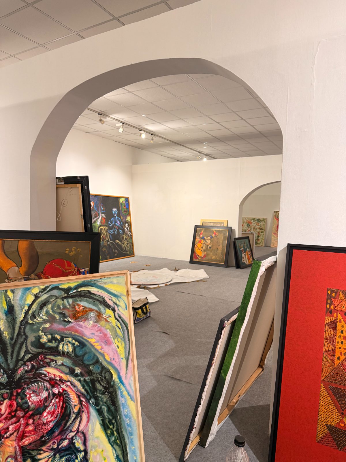 Unhung canvases leaning inside an arched, empty gallery