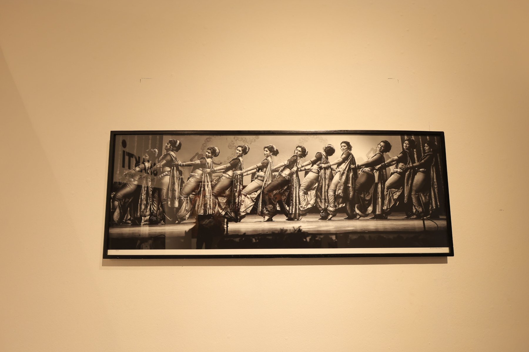 A framed panorama of Lavani dancers in a joyful line across a stage
