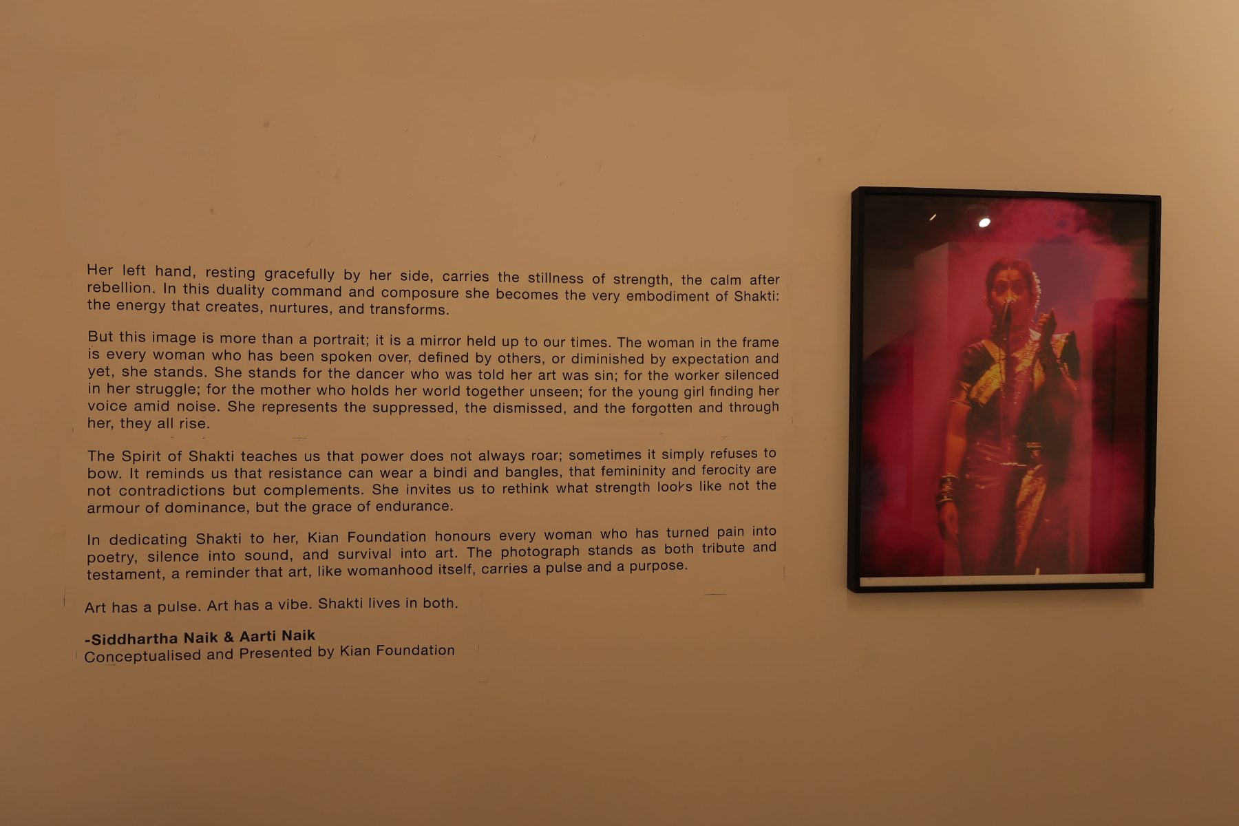 The Spirit of Shakti wall text beside the lavani dancer in magenta light